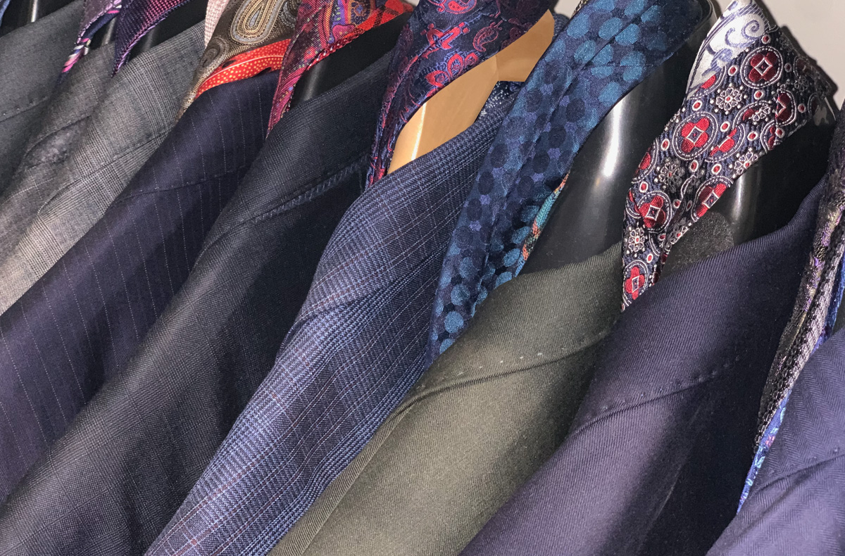 A rack of Lorin's suits arranged by colour and type